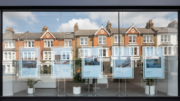 Estate agent window with house listings reflecting terraces