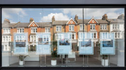 Estate agent window with house listings reflecting terraces