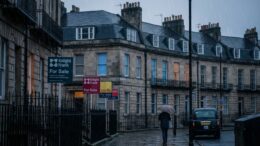 Westminster townhouses with For Sale signs in winter rain