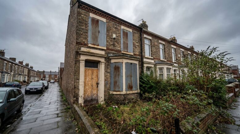 Boarded up empty home on British terraced street