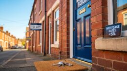 British terraced house with SOLD sign and To Let board