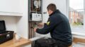 Plumber repairing boiler in UK rental property