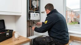 Plumber repairing boiler in UK rental property