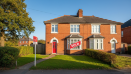 British house with sold sign on sunny day
