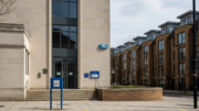 English town hall beside modern rental flats in daylight