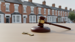 Auction gavel and house key on table