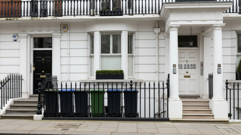 White stucco London HMO exterior with wheelie bins