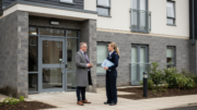 Scottish housing officer outside a modern apartment block