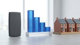 Terraced house models beside a falling blue chart