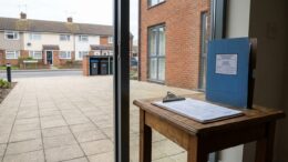 Rental flat entrance with compliance paperwork nearby