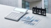 Calculator and abstract rate cards beside a UK rental house