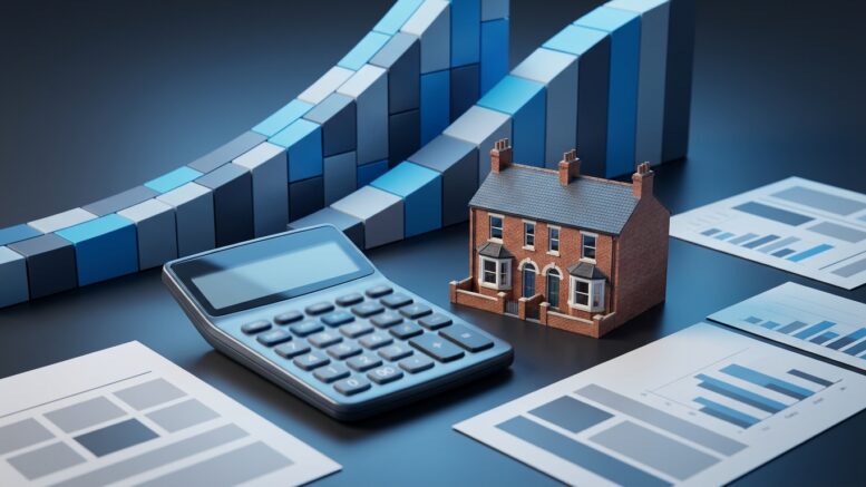 Calculator and rising rate curves beside a British house model