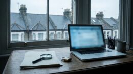 Laptop and magnifying glass in letting agent fraud check