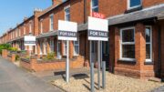 Row of UK brick terraces with For Sale and Sold boards