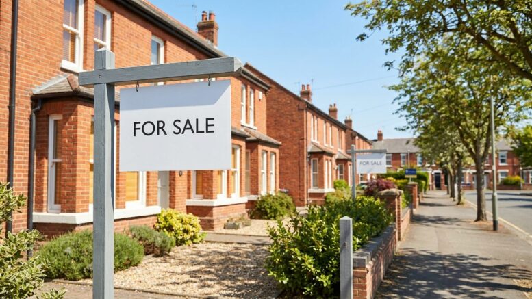 Family houses with For Sale boards on sunny UK street